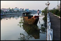 Woman in high heels walking out of barge. Tra Vinh, Vietnam (color)