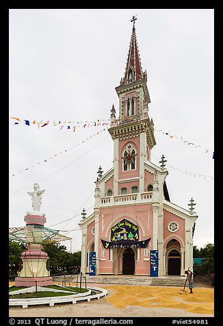 Man drying rice hulls in front of church. Tra Vinh, Vietnam (color)