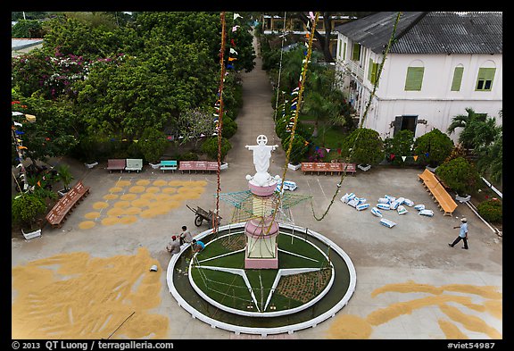 View of drying rice and statue from church tower. Tra Vinh, Vietnam (color)