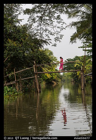 Woman walking across monkey bridge. Can Tho, Vietnam (color)