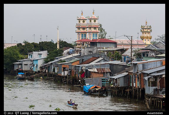 Riverside houses on stilts and Cao Dai temple. Mekong Delta, Vietnam