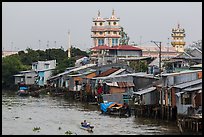 Riverside houses on stilts and Cao Dai temple. Mekong Delta, Vietnam (color)