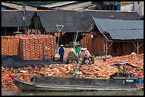 Workers loading bricks on boat. Sa Dec, Vietnam (color)