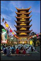 Worshippers and seven story  Quoc Tu pagoda at dusk. Ho Chi Minh City, Vietnam ( color)