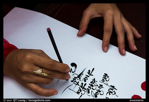 Feminine hand draws Lunar New Year greetings in fancy writing. Ho Chi Minh City, Vietnam (color)