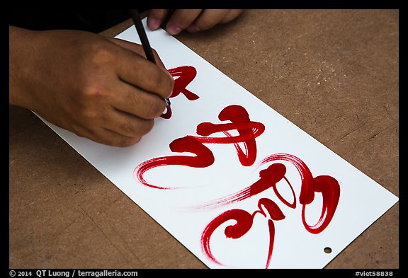 Hands drawing Tet (Lunar New Year) greetings in Chinese characters. Ho Chi Minh City, Vietnam (color)
