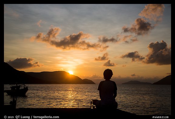 Sitting woman in silhouette and sunrise, Con Son. Con Dao Islands, Vietnam (color)