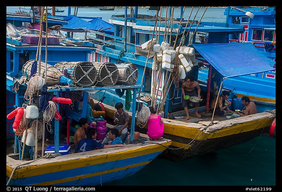 Sailors and families take lunch break at the back of boats, Ben Dam. Con Dao Islands, Vietnam (color)