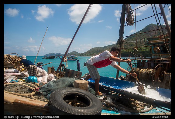 Man scoops ice into fishing boat, Ben Dam. Con Dao Islands, Vietnam (color)