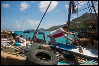 Man scoops ice into fishing boat, Ben Dam. Con Dao Islands, Vietnam ( color)