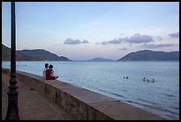 Young women sitting on seawall, evening, Con Son. Con Dao Islands, Vietnam ( color)