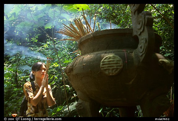 Tourist praying at an urn with incense near the entrance of Phong Nha Cave. Vietnam (color)