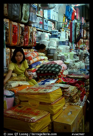 Vendor sitting amongst Abondance of cheap goods imported from nearby China at the Dong Kinh Market. Lang Son, Northest Vietnam (color)