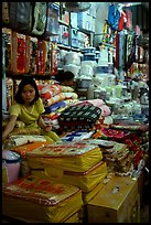 Vendor sitting amongst Abondance of cheap goods imported from nearby China at the Dong Kinh Market. Lang Son, Northest Vietnam (color)