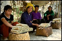 Women selling sweet rice cooked in bamboo tubes. Vietnam