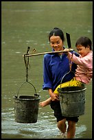 Woman of the Tay minority carrying crossing the river with child, Ba Be Lake. Vietnam ( color)