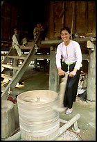 Woman of the Thai ethnicity milling grain, near Mai Chau. Northwest Vietnam (color)