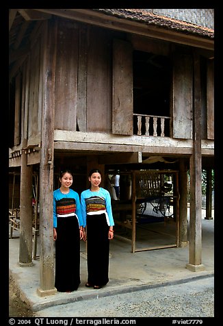 Two thai women standing in front of their stilt house, Ban Lac village. Northwest Vietnam (color)