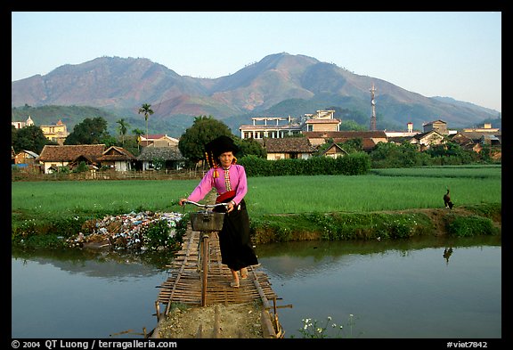 Thai woman pushing her bicycle across a bridge, Tuan Giao. Northwest Vietnam (color)