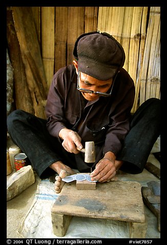 Dzao man crafting the decorative coins used in the children hats, between Tam Duong and Sapa. Northwest Vietnam