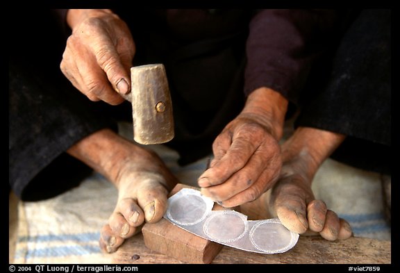 Hands and feet of a Black Dzao man making decorative coins, between Tam Duong and Sapa. Northwest Vietnam