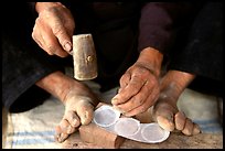 Hands and feet of a Black Dzao man making decorative coins, between Tam Duong and Sapa. Northwest Vietnam