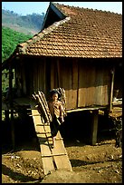 Montagnard child carries logs out of her house, between Tuan Giao and Lai Chau. Northwest Vietnam