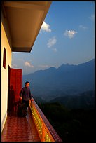 Traveler on a hotel balcony, looking at the Hoang Lien Mountains. Sapa, Vietnam (color)