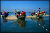 Fishermen get their nets out of their small fishing boats. Vung Tau, Vietnam