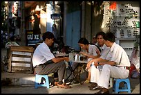 Enjoying a cafe on the streets, sitting on the typical tiny chairs. Ho Chi Minh City, Vietnam (color)