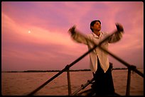 Boater using the X-shaped paddle characteristic of the Delta, sunset. Can Tho, Vietnam