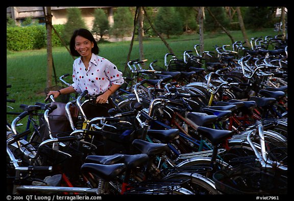 Woman retrieving her bicycle from a bicyle parking area. Mekong Delta, Vietnam (color)