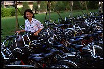 Woman retrieving her bicycle from a bicyle parking area. Mekong Delta, Vietnam (color)
