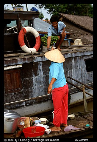 Passsing a bowl of pho from boat to boat. Can Tho, Vietnam