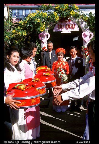 Gifts are exchanged as a newly wedded couple exits the bride's home. Ho Chi Minh City, Vietnam (color)