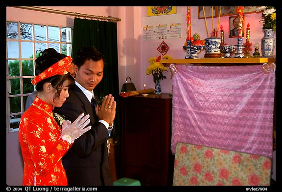 Newly-wed couple prays at the groom's ancestral altar. Ho Chi Minh City, Vietnam (color)