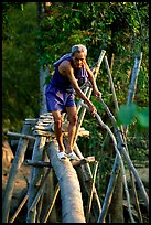 Elderly man not afraid of crossing a bamboo bridge, near Long Xuyen. Vietnam