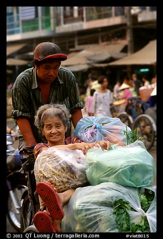 Elderly woman back from the market with plenty of groceries makes good use of cyclo. Cholon, Ho Chi Minh City, Vietnam