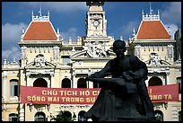 Bronze memorial to Ho Chi Minh by artist Diep Minh Chau and city hall. Ho Chi Minh City, Vietnam ( color)