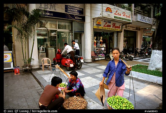 Old and new: street fruit vendors and computer store. Ho Chi Minh City, Vietnam