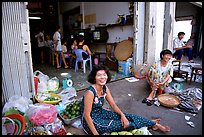 Old and new: street vendors and kids playing in a video games store. Ho Chi Minh City, Vietnam