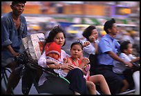 Wheels are seldom for single drivers: families on cyclo and motorbike. Ho Chi Minh City, Vietnam (color)