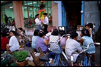 Watching TV on the street with the neighboors. Ho Chi Minh City, Vietnam (color)