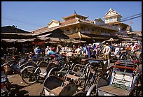 Cyclos wait outside the Bin Tay market in Cholon, the Ethnic-chinese vibrant business district whose name means Big Market. Ho Chi Minh City , Vietnam ( color)