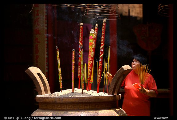 Offering incense at a Chinese temple in Cho Lon. Cholon, District 5, Ho Chi Minh City, Vietnam (color)