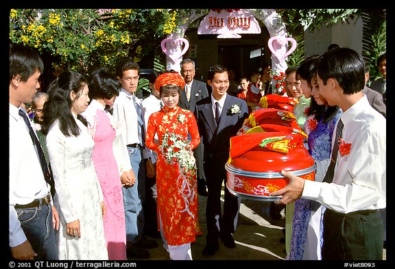 Exchange of gifts at wedding, upon exiting bride's home. The bride traditionaly wears red. Ho Chi Minh City, Vietnam (color)