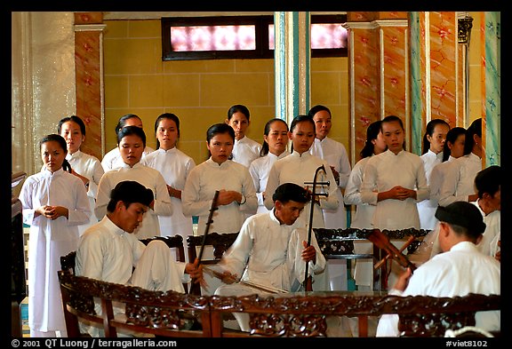 Traditional musicians during the noon ceremony. Tay Ninh, Vietnam (color)