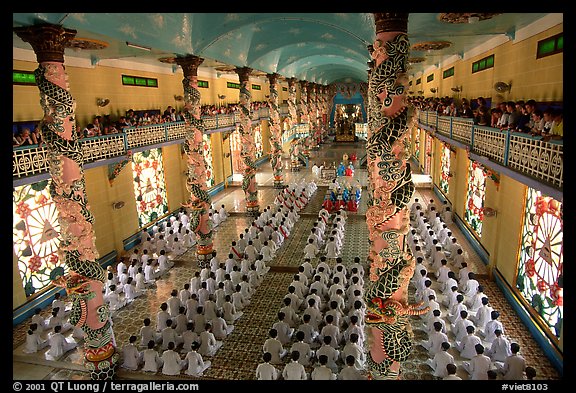 The noon ceremony, attended by priests inside the great Cao Dai temple. Tay Ninh, Vietnam (color)