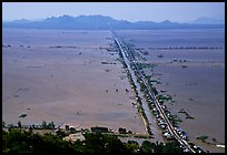 Stilts houses line a road traversing inundated rice fields, seen from Sam mountain. Cambodia is in the far. Chau Doc, Vietnam (color)