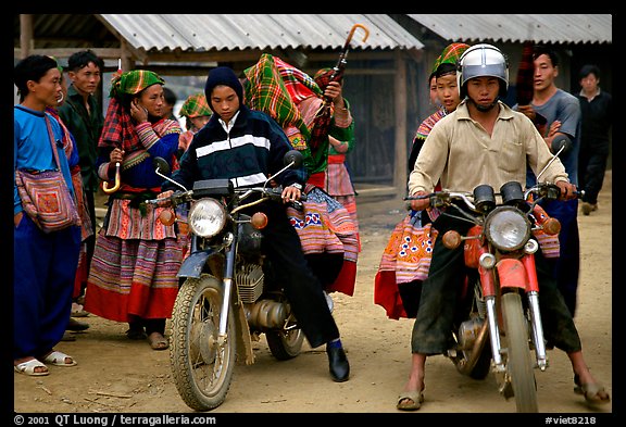 Flower Hmong women getting a ride on all-terrain russian-made motorbikes to the sunday market. Bac Ha, Vietnam (color)